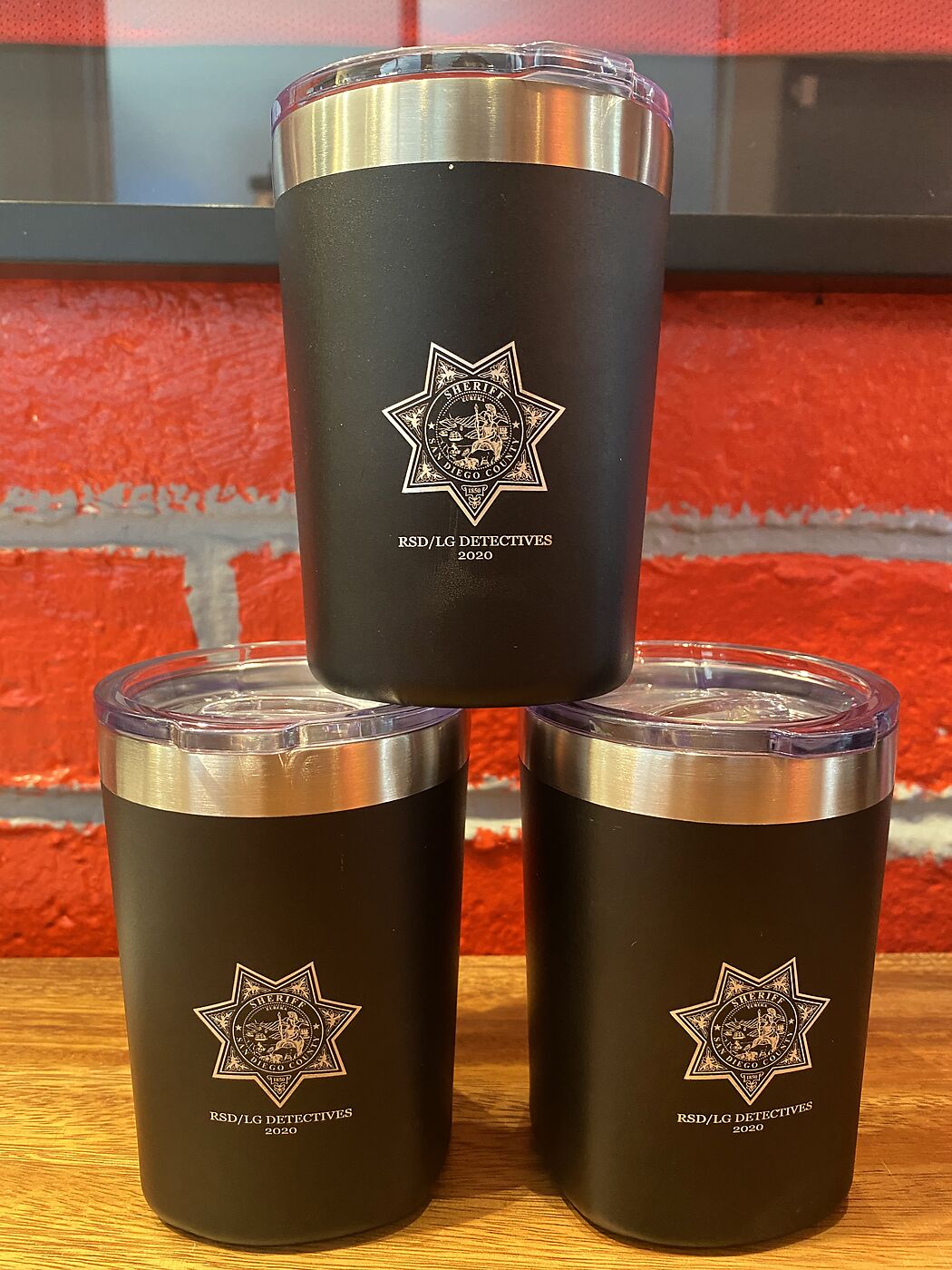 Three black tumblers engraved with a sheriff detectives badge